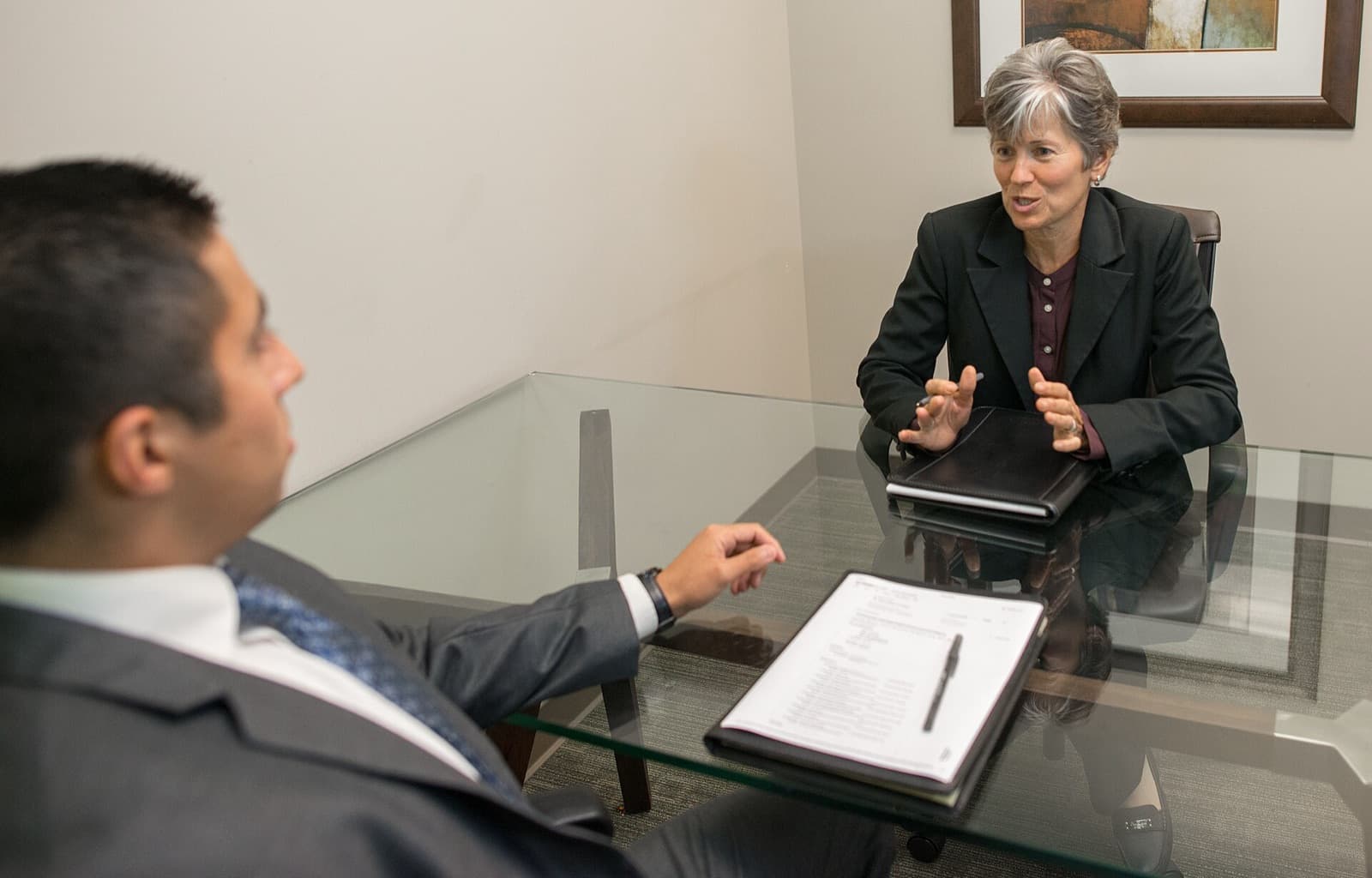 An interviewer with her notes, listening to a candidate