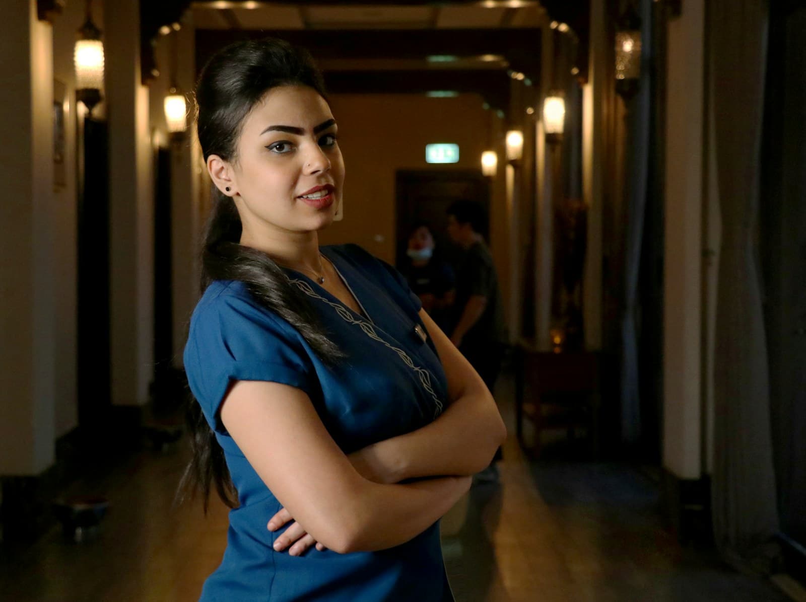 A nurse in scrubs in a hospital corridor