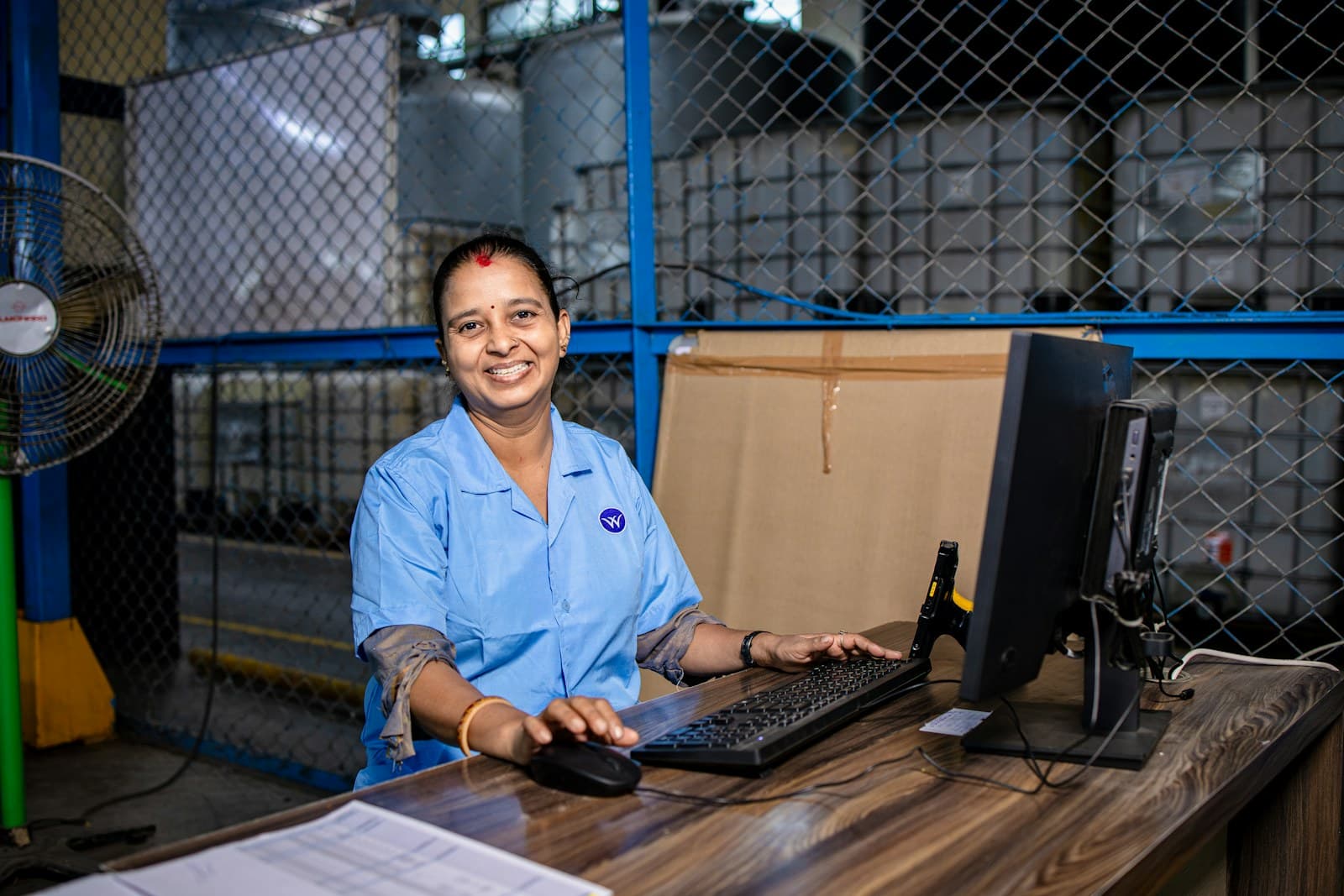 A supervisor at her desk in a warehouse